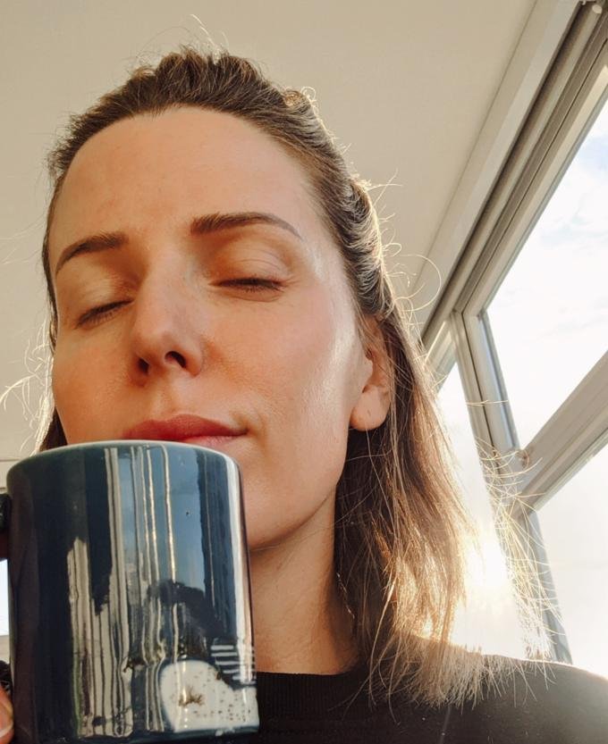 Breanne with a mug of green tea in morning sun