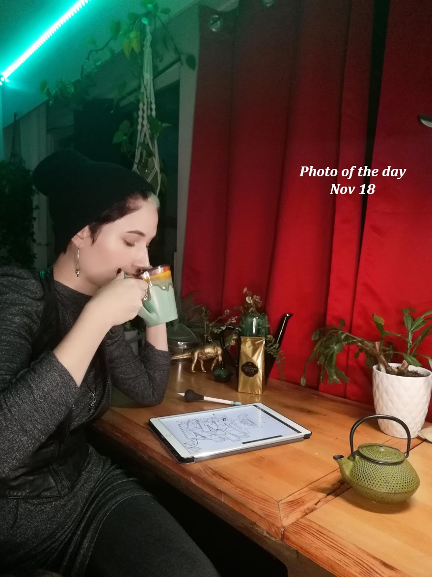 Marie drinking tea at her drawing desk at night
